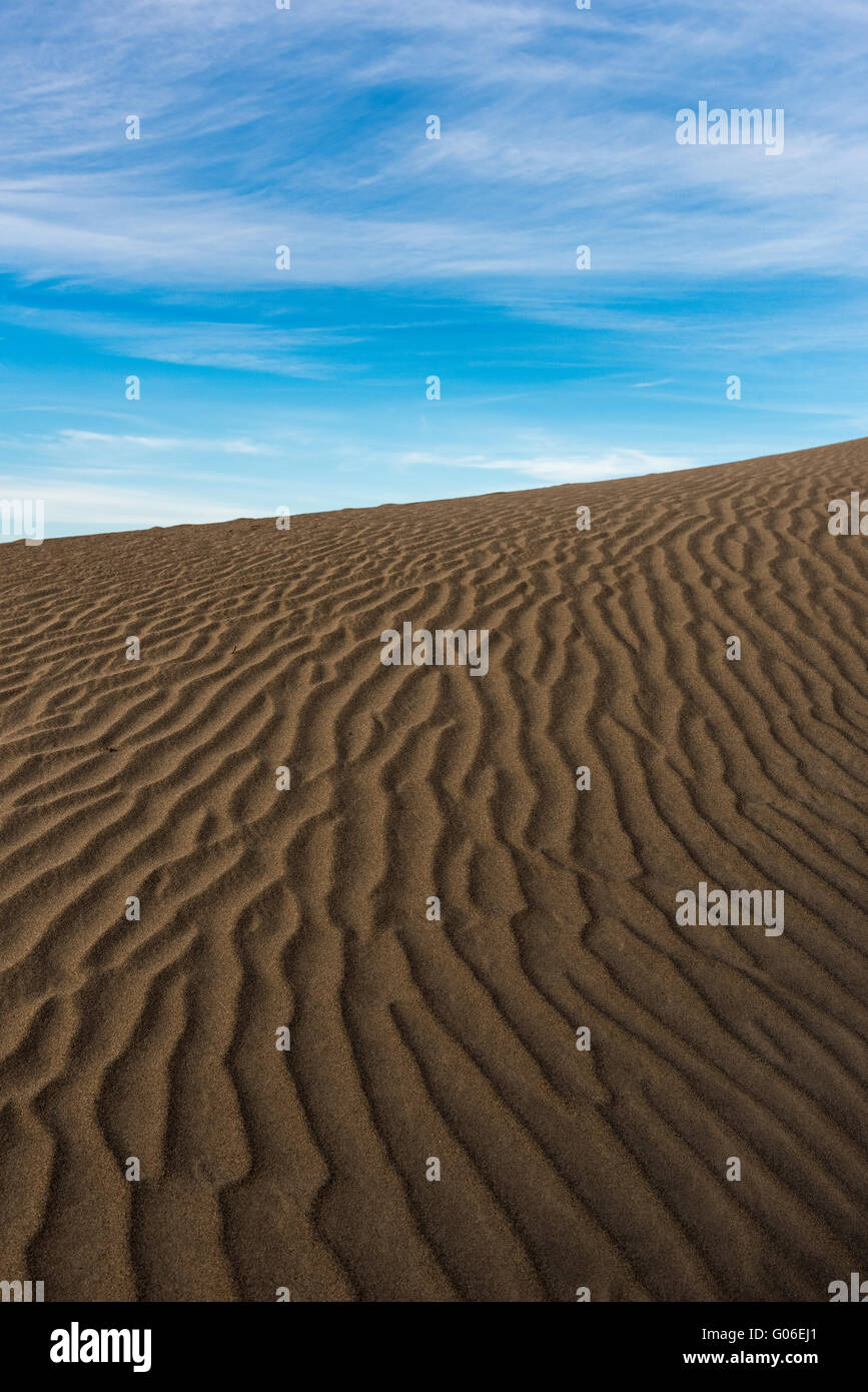 Dunes de sable texturé contre un ciel bleu. Banque D'Images