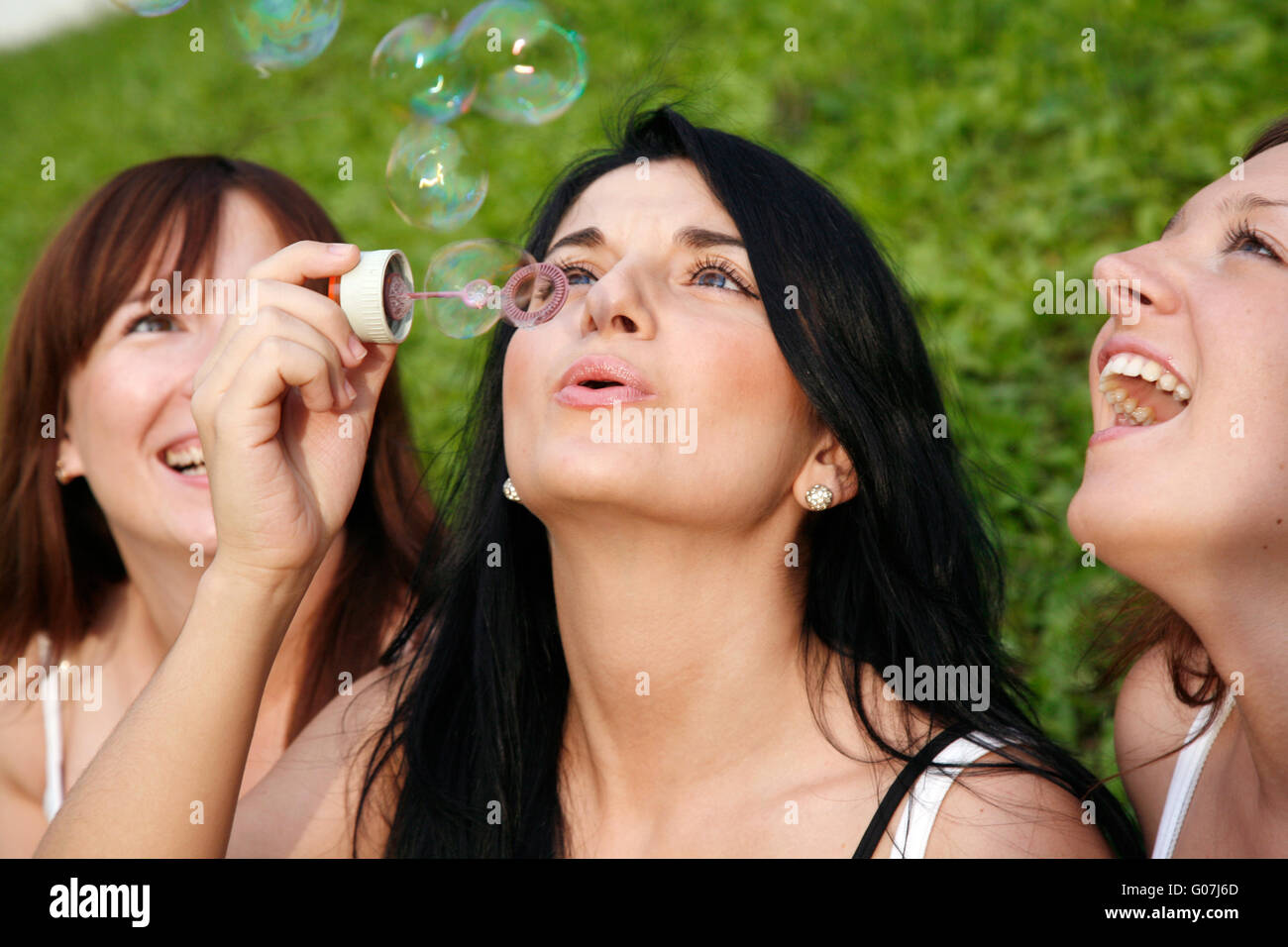 Girl friends avec des bulles de savon outdoor Banque D'Images