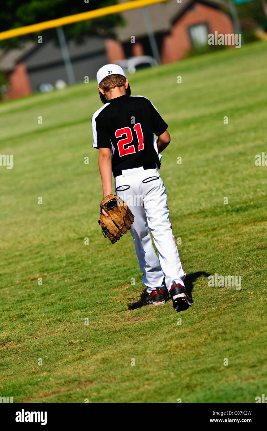 Joueur de baseball des jeunes marcher sur terrain Banque D'Images