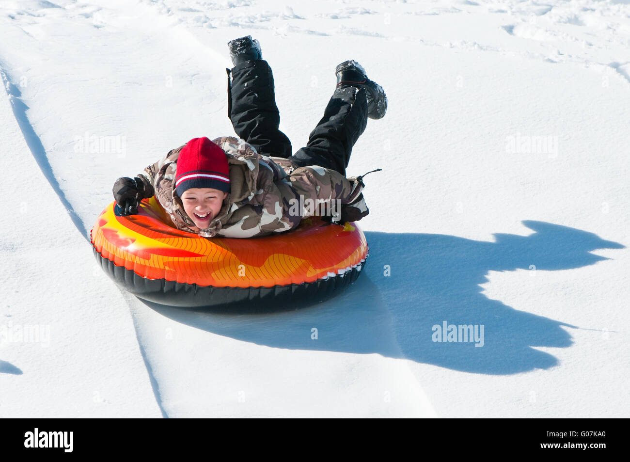 Happy boy sleding dans un tube. Banque D'Images