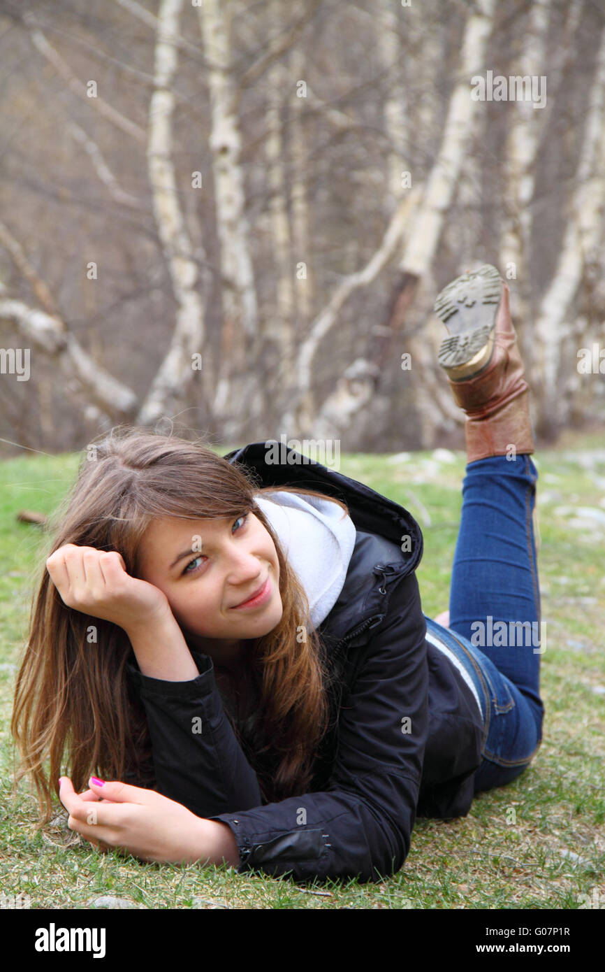 Belle jeune fille couchée sur l'herbe et smilin Banque D'Images