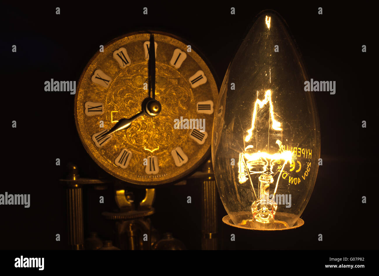 Lluminous et ampoule decorativ face à une horloge hall Banque D'Images