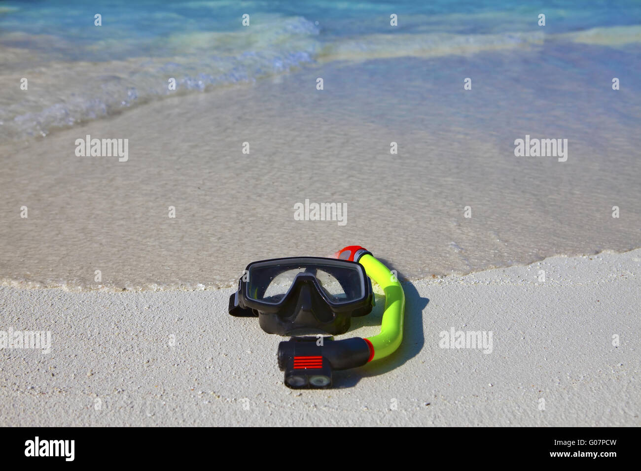 Masque, palmes, un tube à poser sur du sable sur fond de Banque D'Images