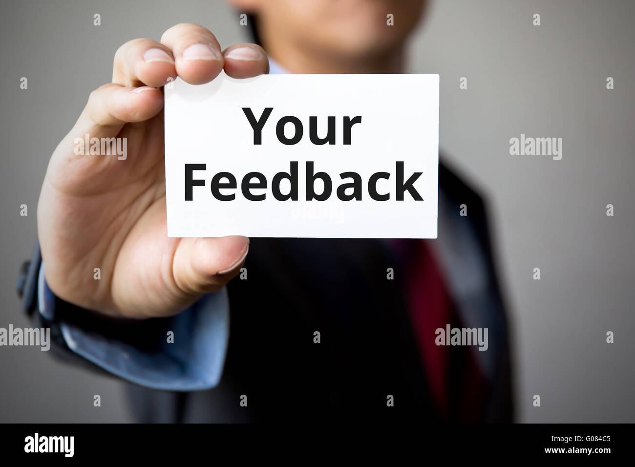 Businessman presenting 'Vos commentaires' mot sur carte blanche Banque D'Images
