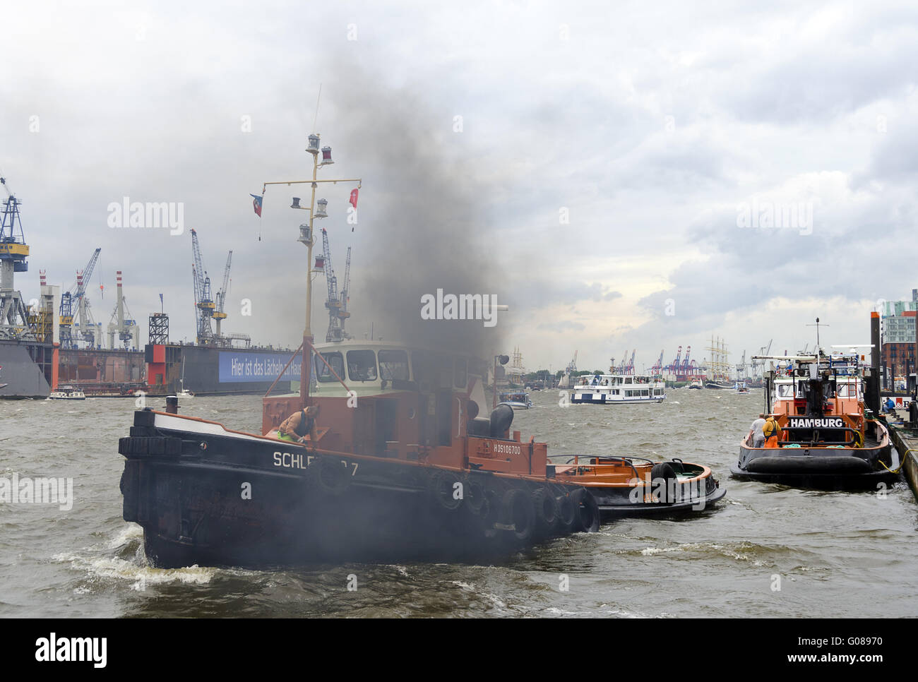 Remorqueur de larguer les amarres de la jetée dans un nuage de fumée Banque D'Images