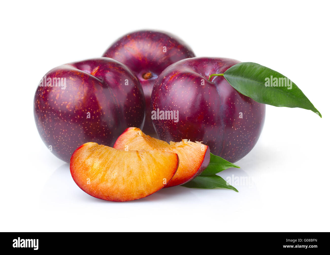 Les fruits mûrs de prune violet vert avec des feuilles isolées Banque D'Images