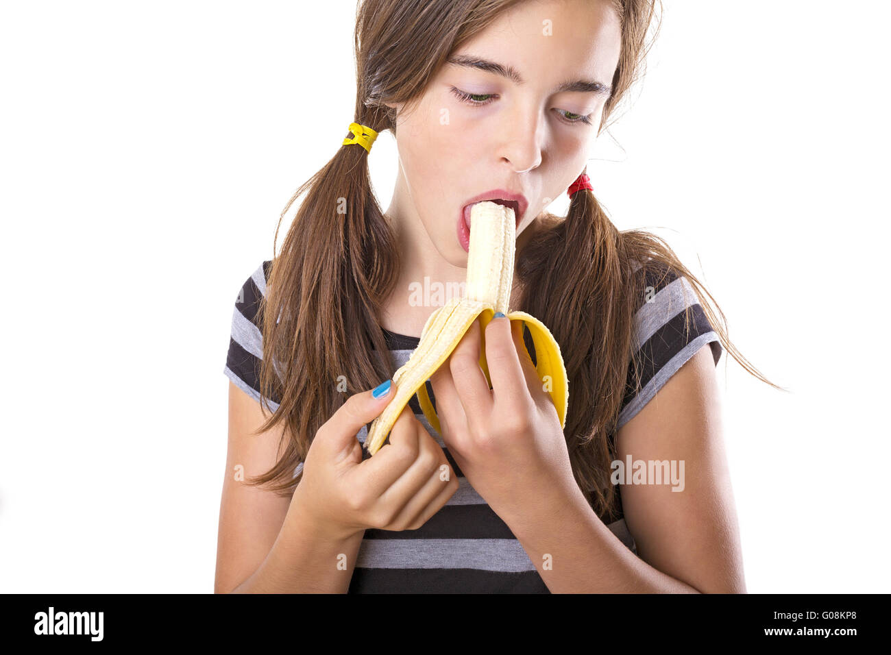Teenage girl with banana dans ici bouche, isolated on white Banque D'Images