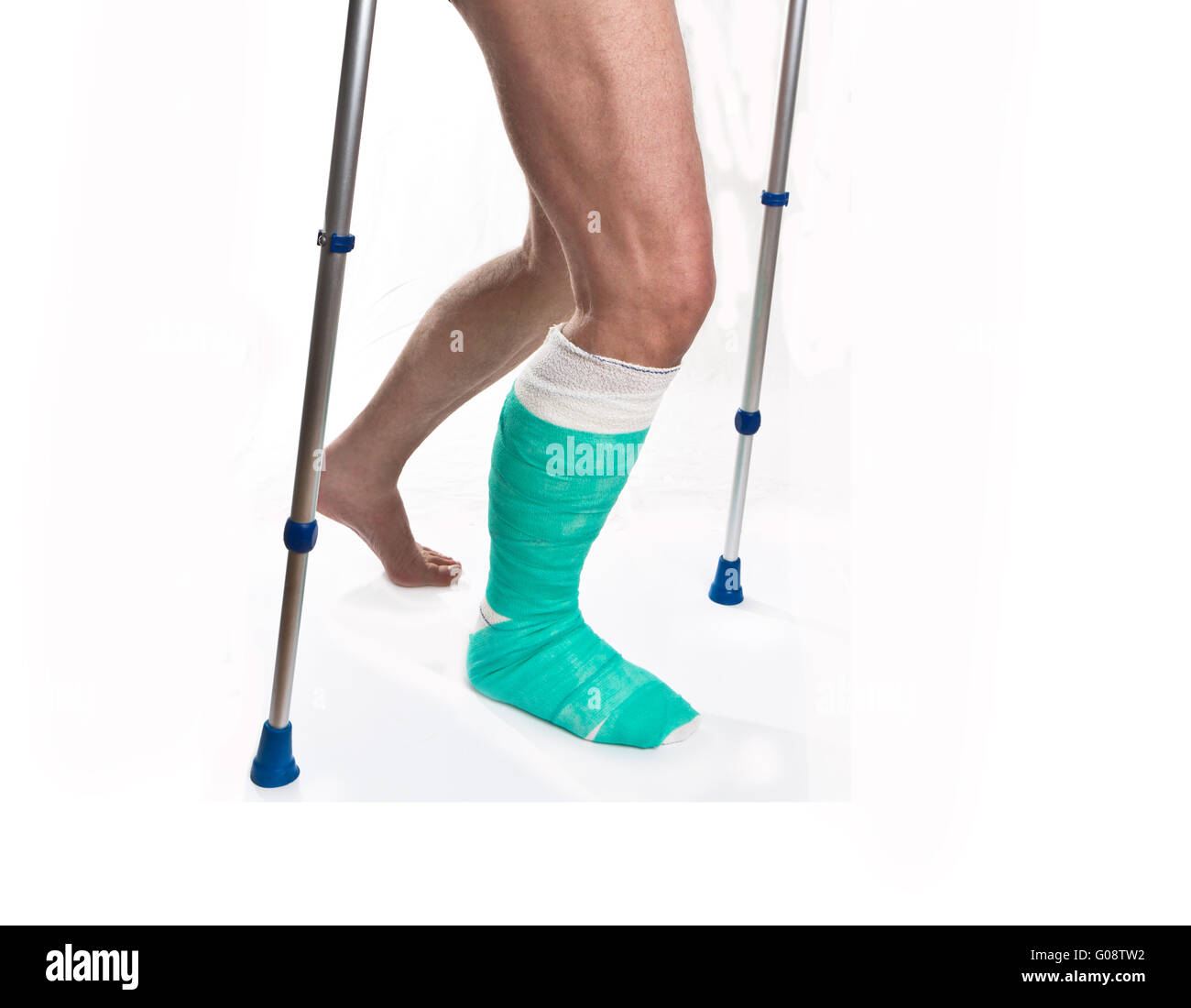 Homme avec une jambe cassée avec des béquilles sur fond blanc Banque D'Images