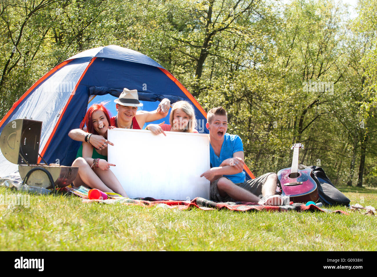 Les adolescents sur un camping avec un panneau vide Banque D'Images