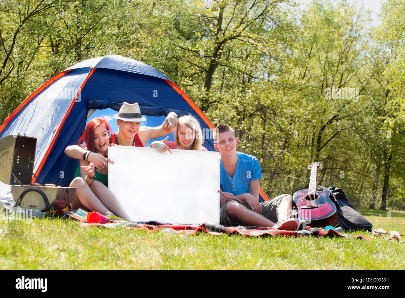 Les jeunes sur un camping avec un panneau vide Banque D'Images