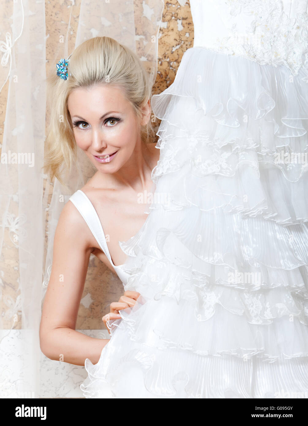 La jeune femme près d'une robe de mariage de rêves Banque D'Images
