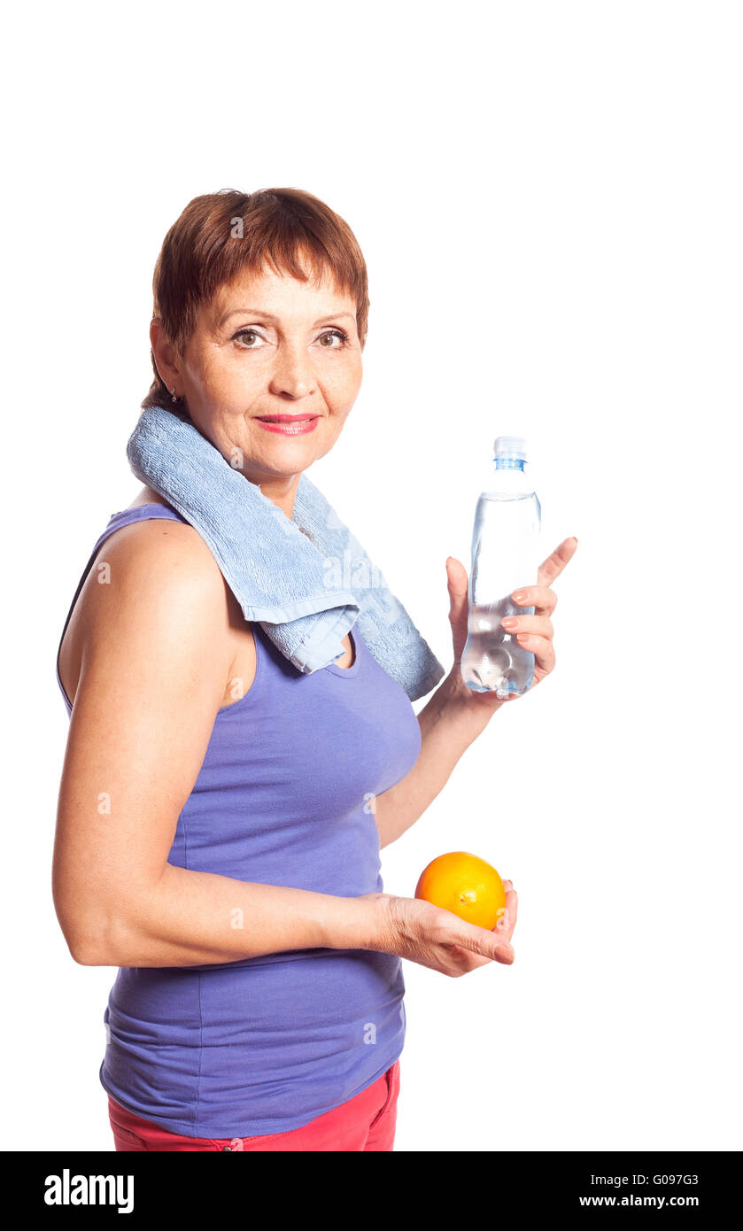 Jolie femme de 50 ans avec une orange et une bouteille d'eau Banque D'Images