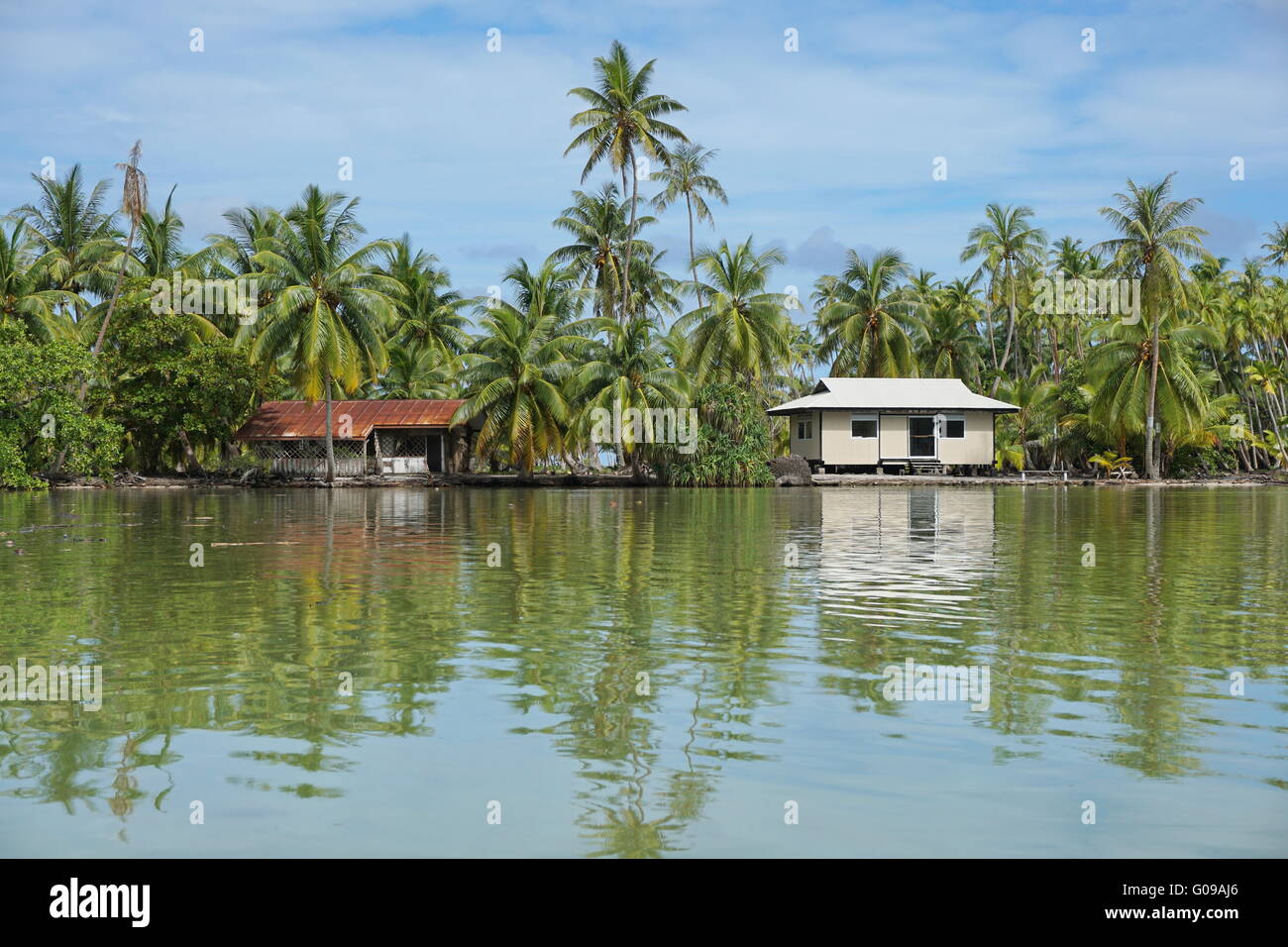 Côte Tropicale d'un îlot avec cocotiers et maison typiquement polynésien, Huahine island, Pacifique, Polynésie Française Banque D'Images