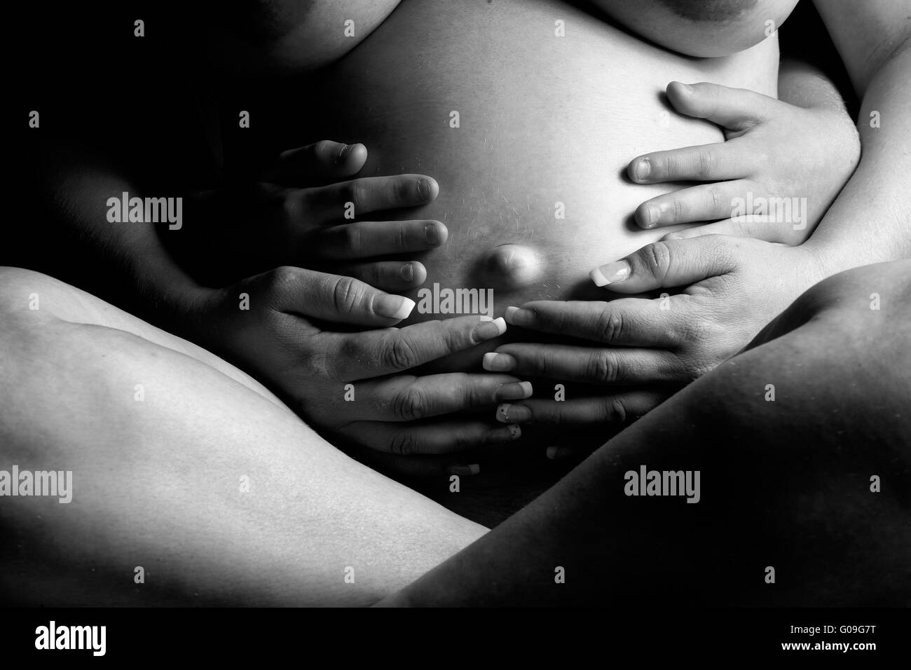 Quatre mains tenant et de sentir mon ventre enceinte Banque D'Images