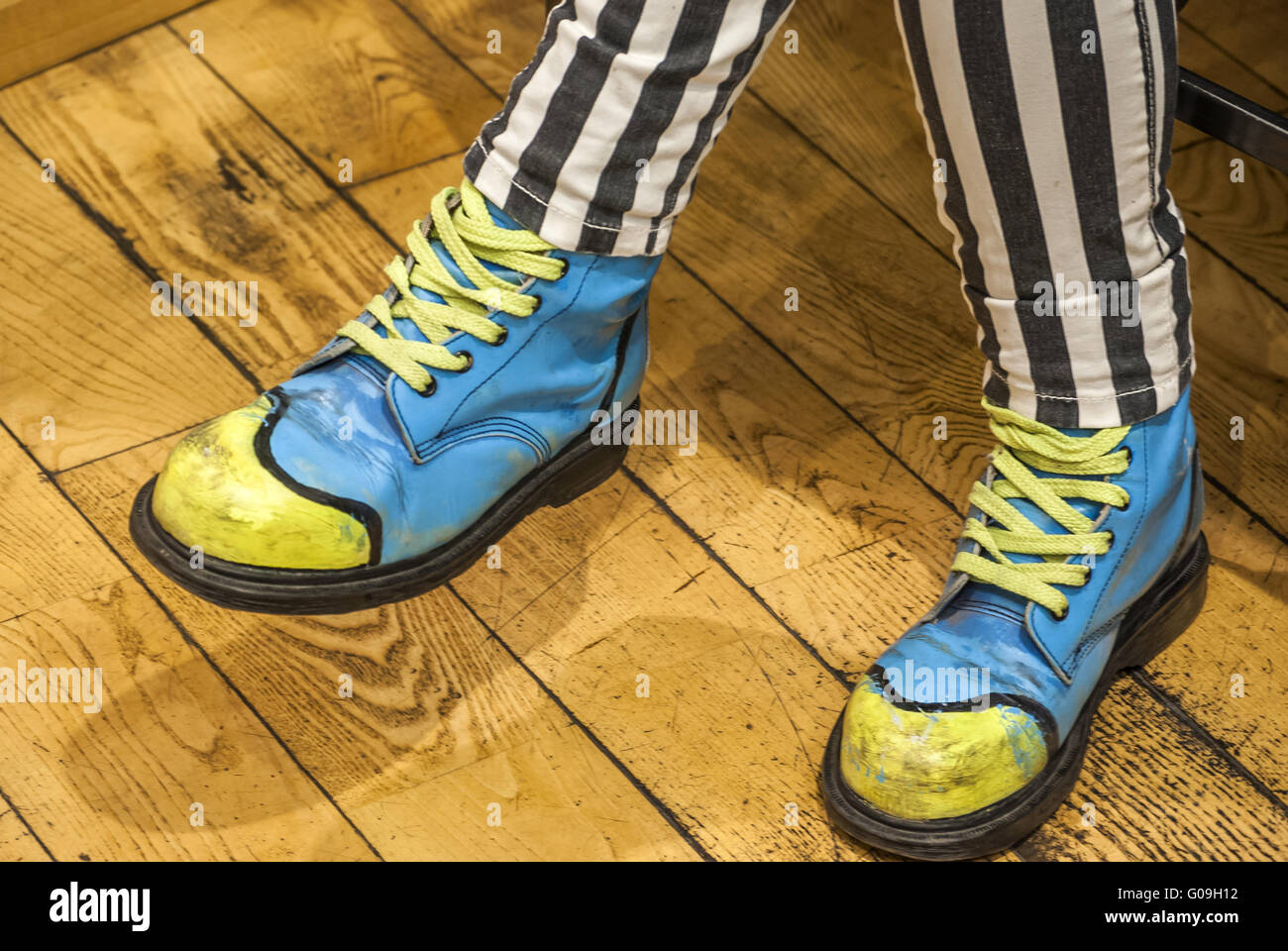 Les jambes des femmes avec des chaussures colorées sur plancher en bois Banque D'Images