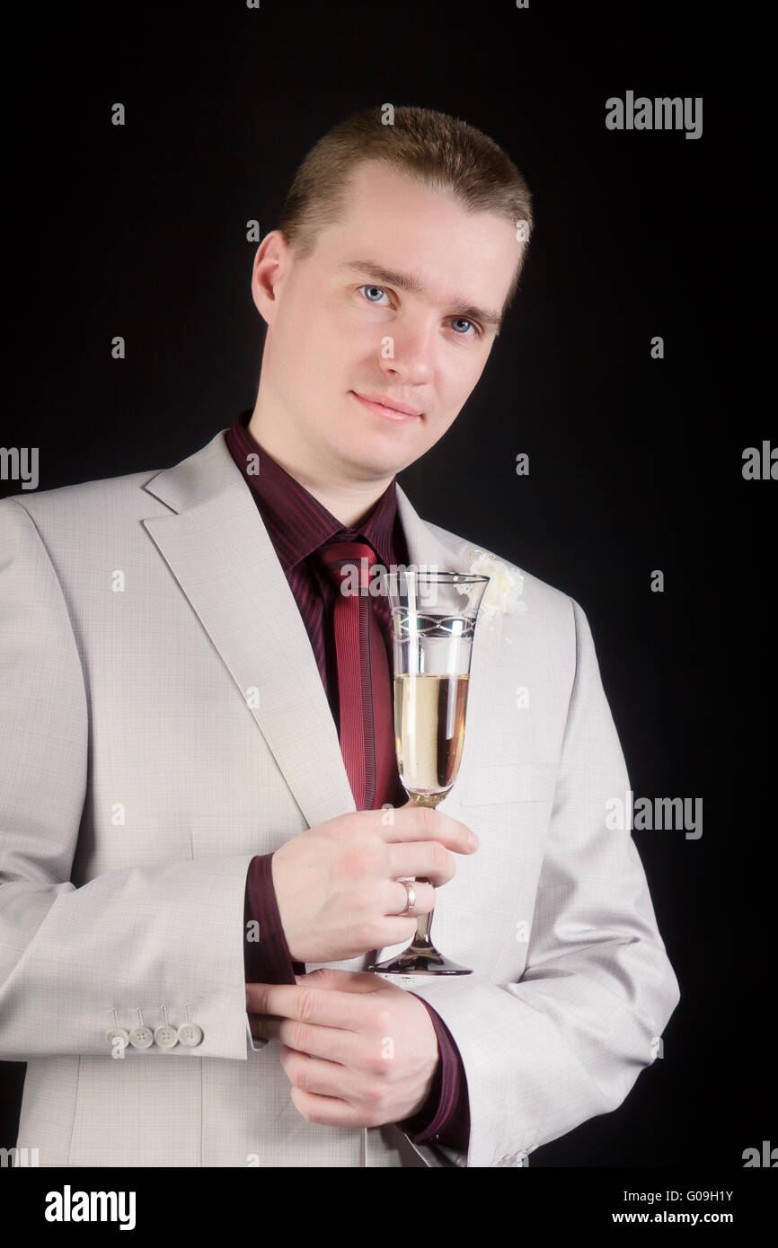 Jeune homme en costume avec un verre de champagne Banque D'Images