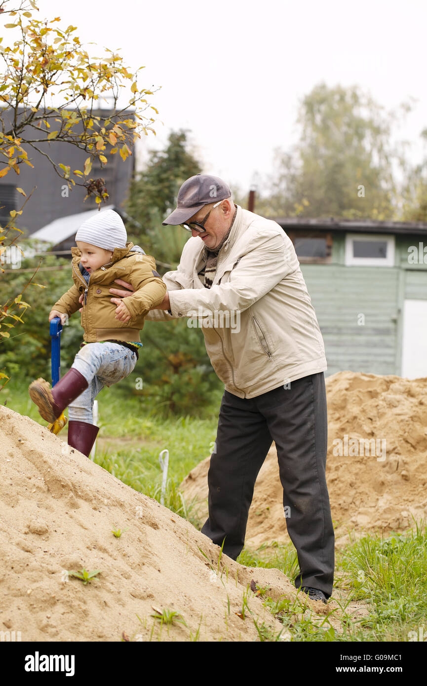 Aide grand-père petit-fils d'aller sur une colline de sable Banque D'Images