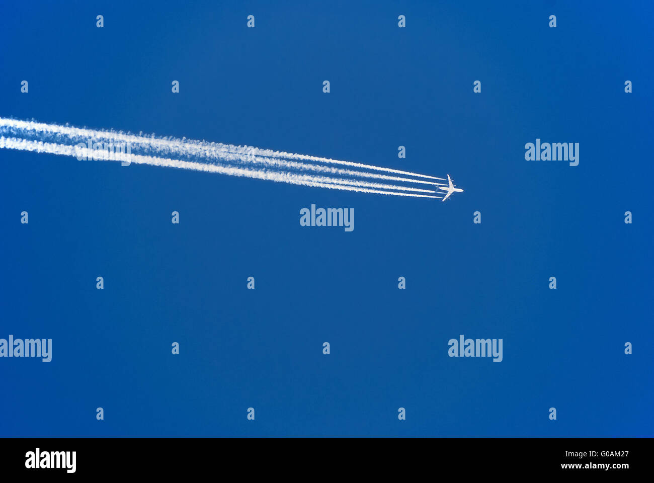 Avion avec les traînées de condensation à blue sky Banque D'Images