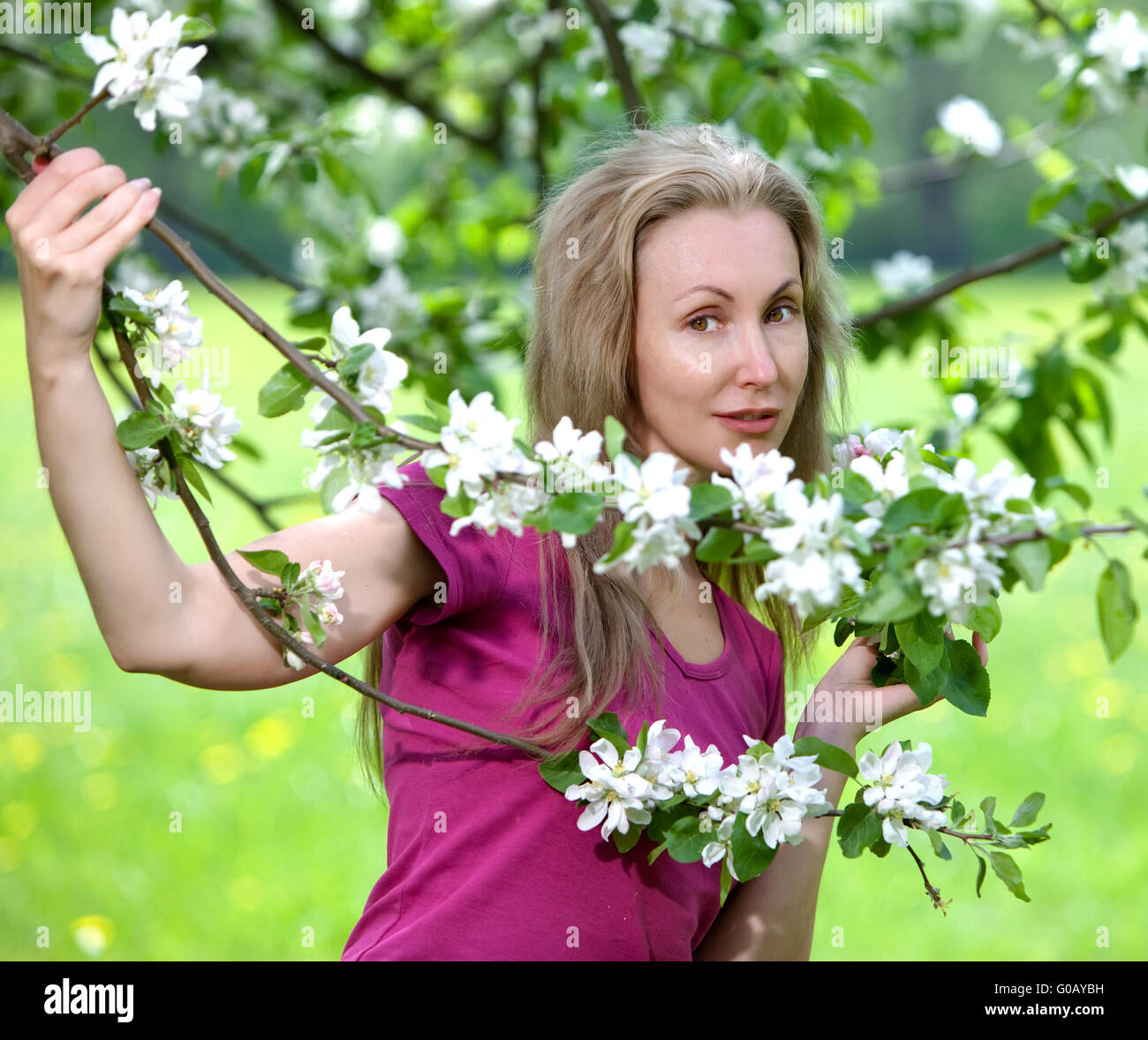 Jolie femme debout près de la floraison app Banque D'Images
