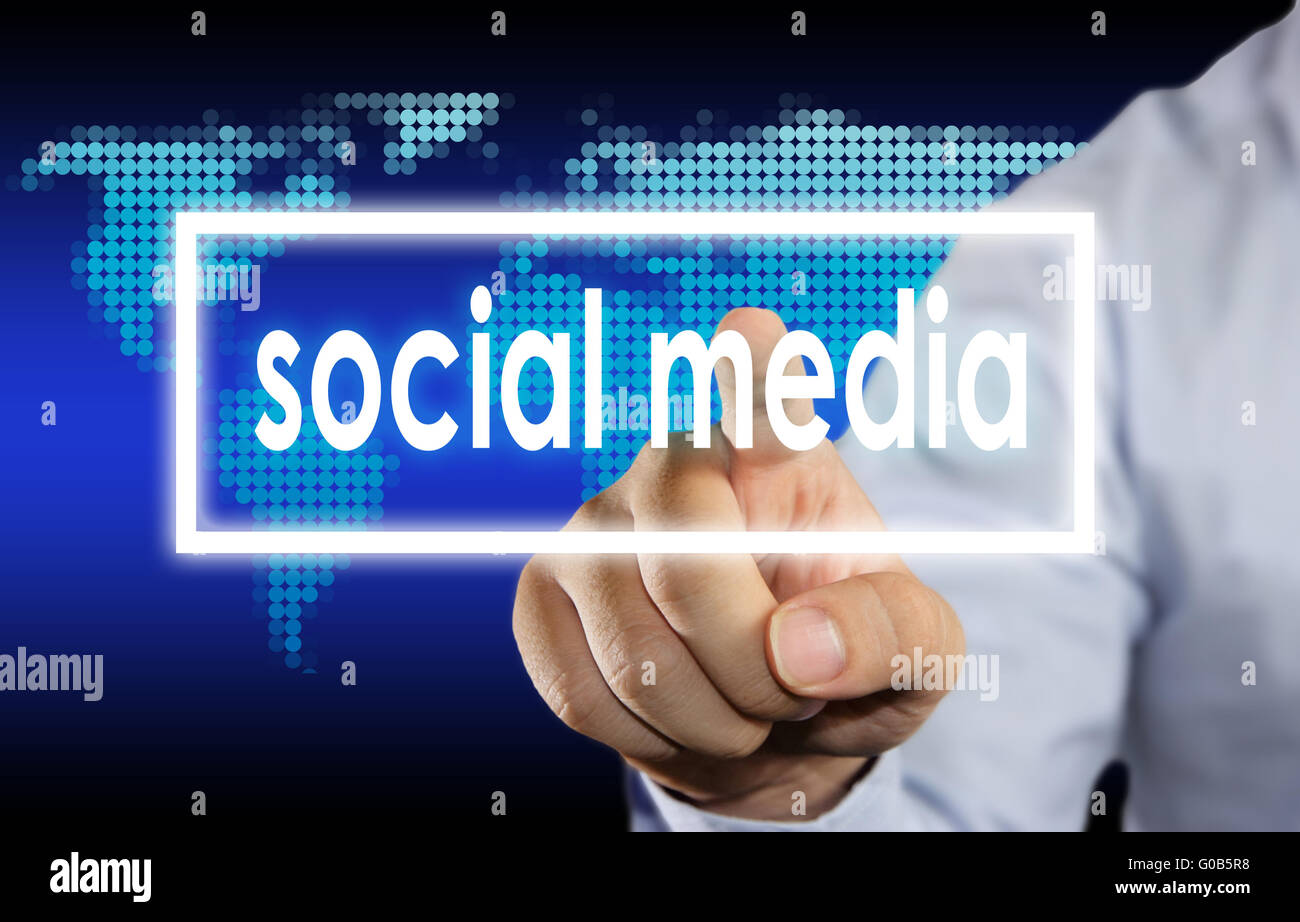 Businessman en cliquant sur les médias sociaux mots sur un écran virtuel Banque D'Images