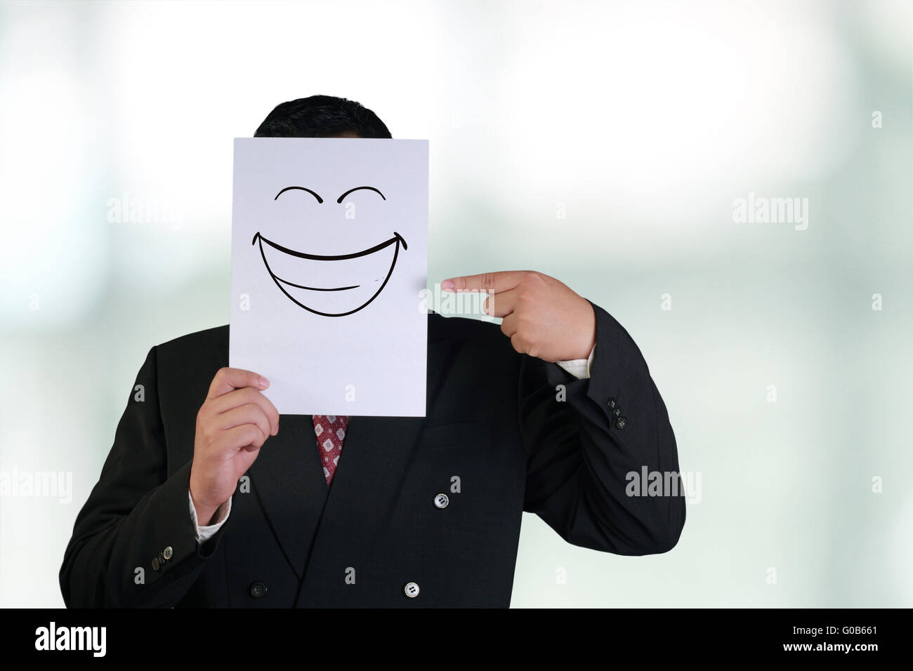 Concept d'image d'un couple et de pointage papier blanc avec masque visage rire heureux dessiné dessus Banque D'Images