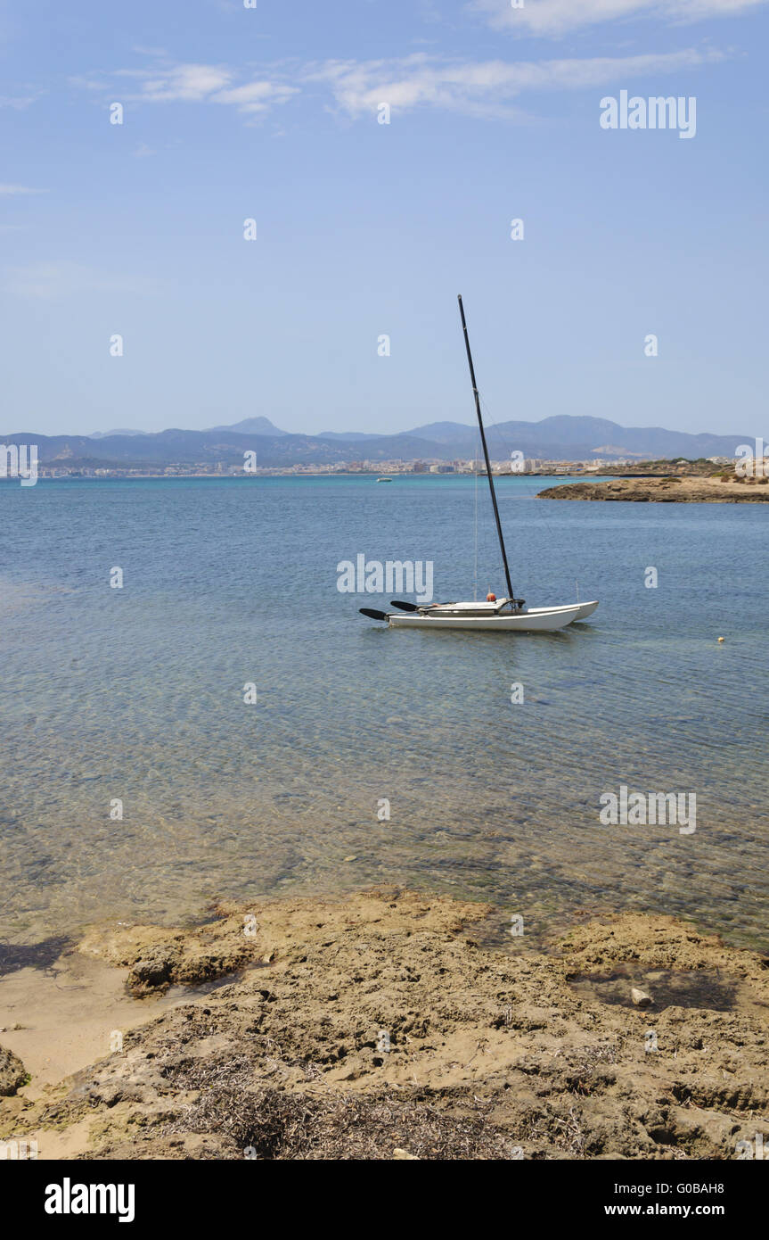 Voilier amarré dans les eaux peu profondes Cala Estancia Banque D'Images