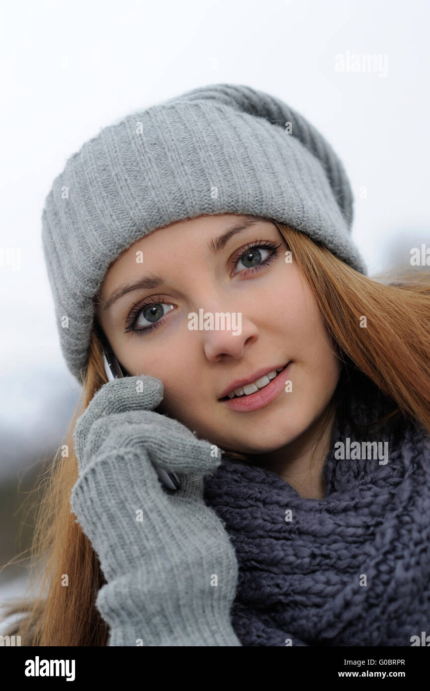 Jeune femme portant des vêtements d'hiver mobile avec Banque D'Images