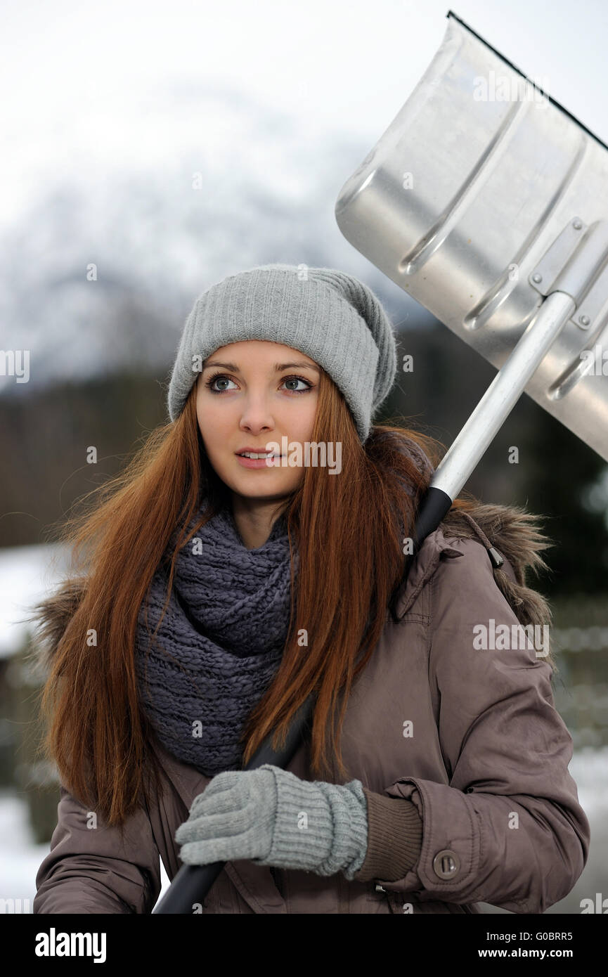 Jeune femme avec pelle à neige Banque D'Images