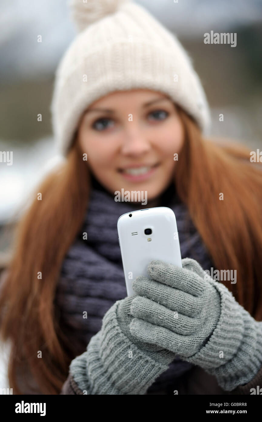 Jeune femme portant des vêtements d'hiver mobile avec Banque D'Images