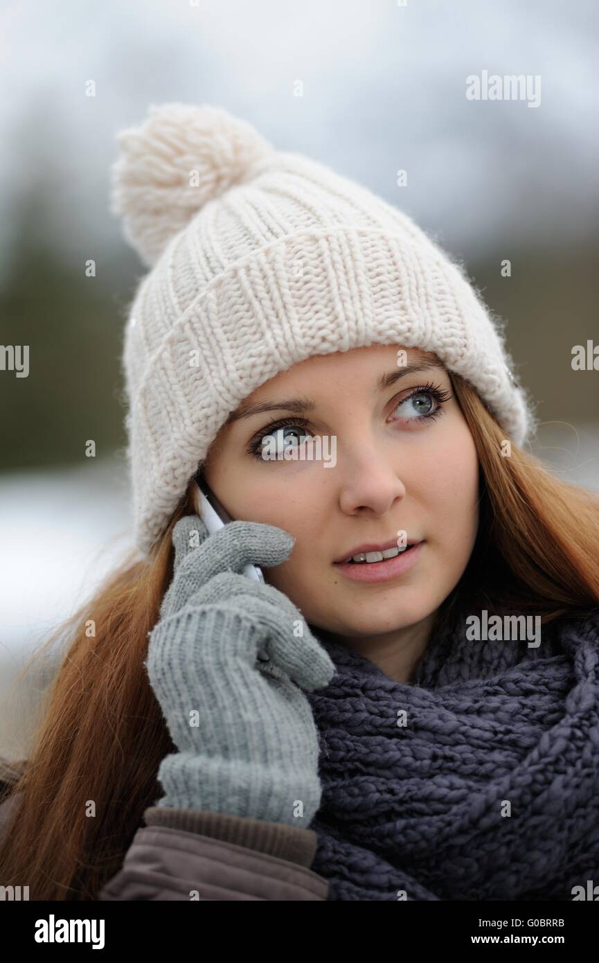 Jeune femme portant des vêtements d'hiver mobile avec Banque D'Images