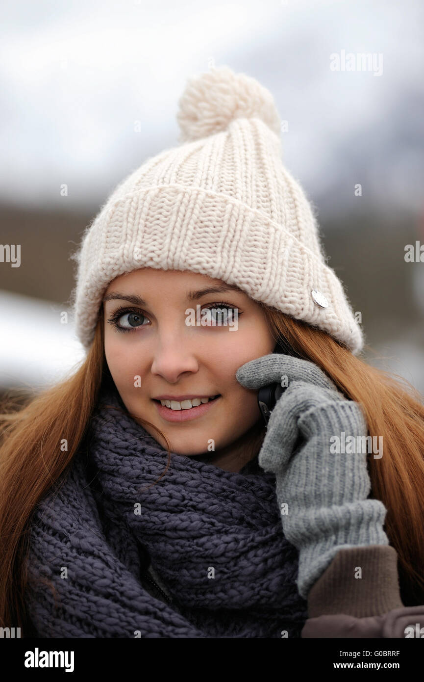 Jeune femme portant des vêtements d'hiver mobile avec Banque D'Images