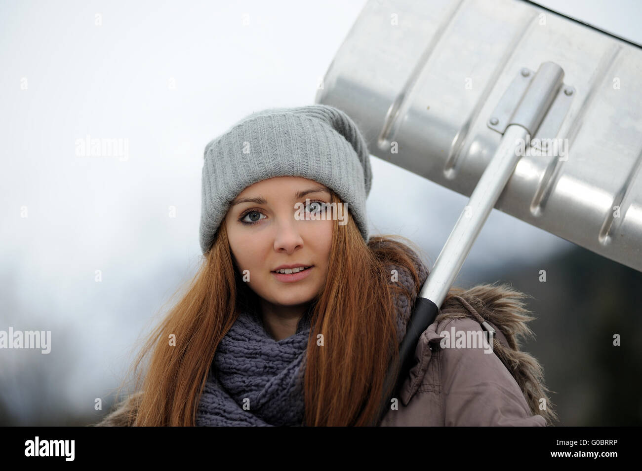 Jeune femme avec pelle à neige Banque D'Images