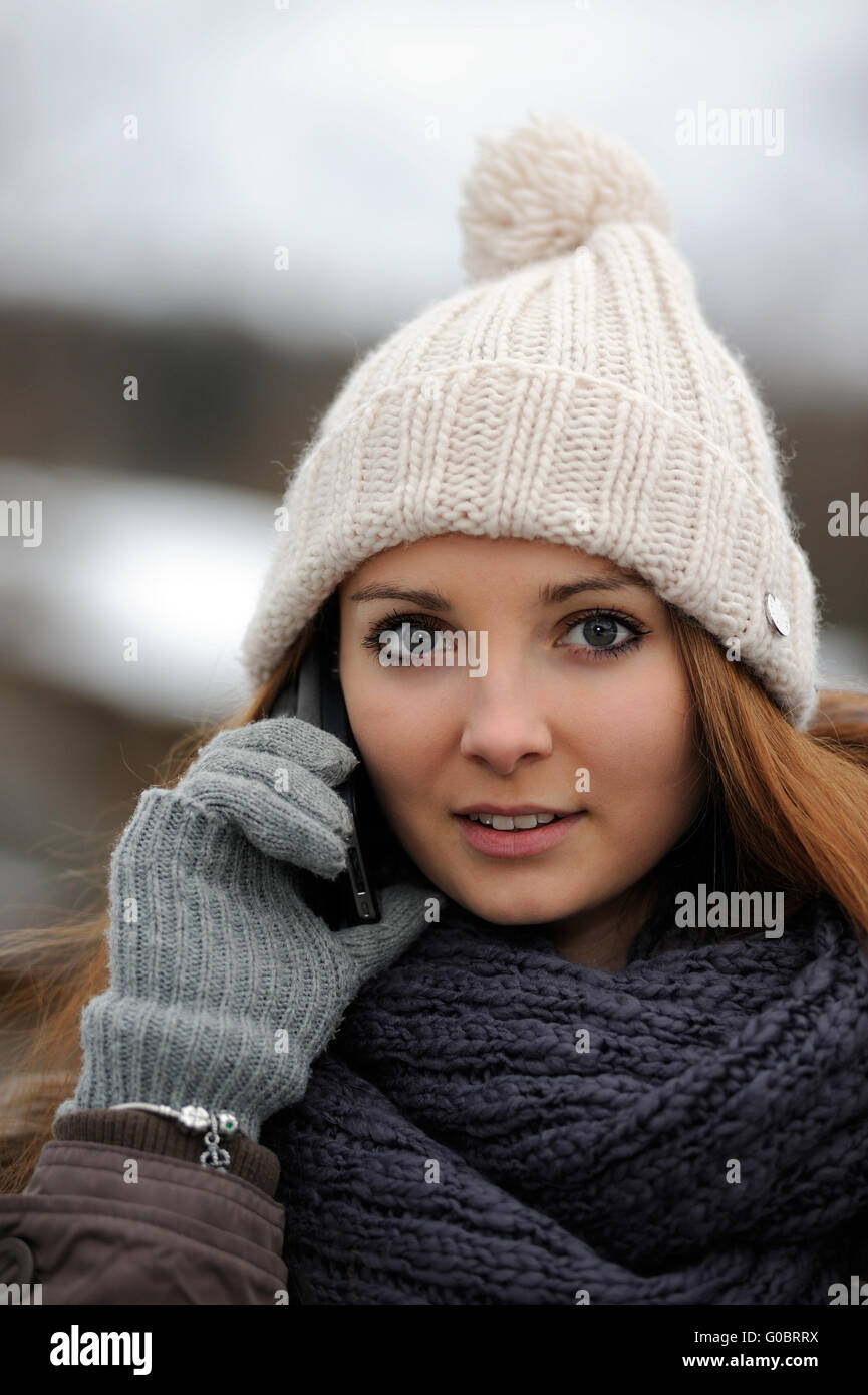 Jeune femme portant des vêtements d'hiver mobile avec Banque D'Images