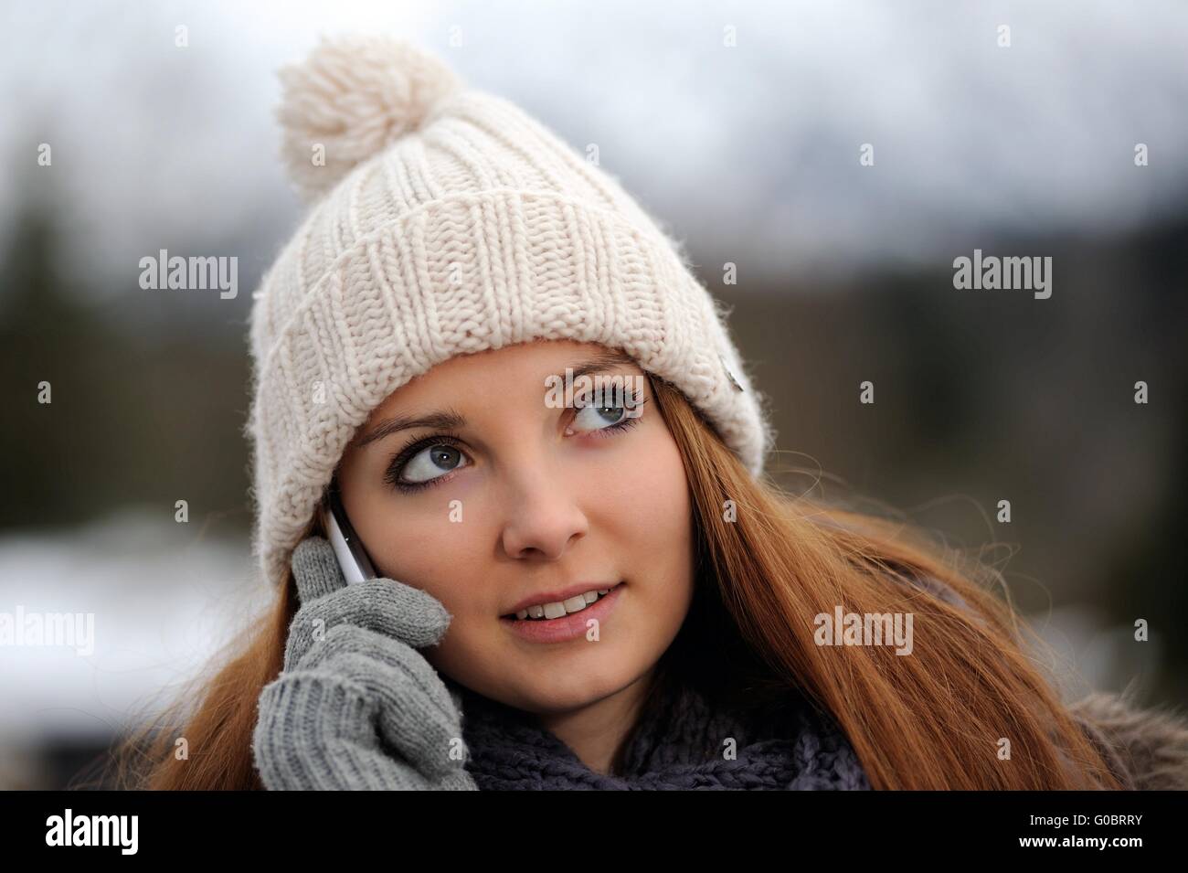 Jeune femme portant des vêtements d'hiver mobile avec Banque D'Images