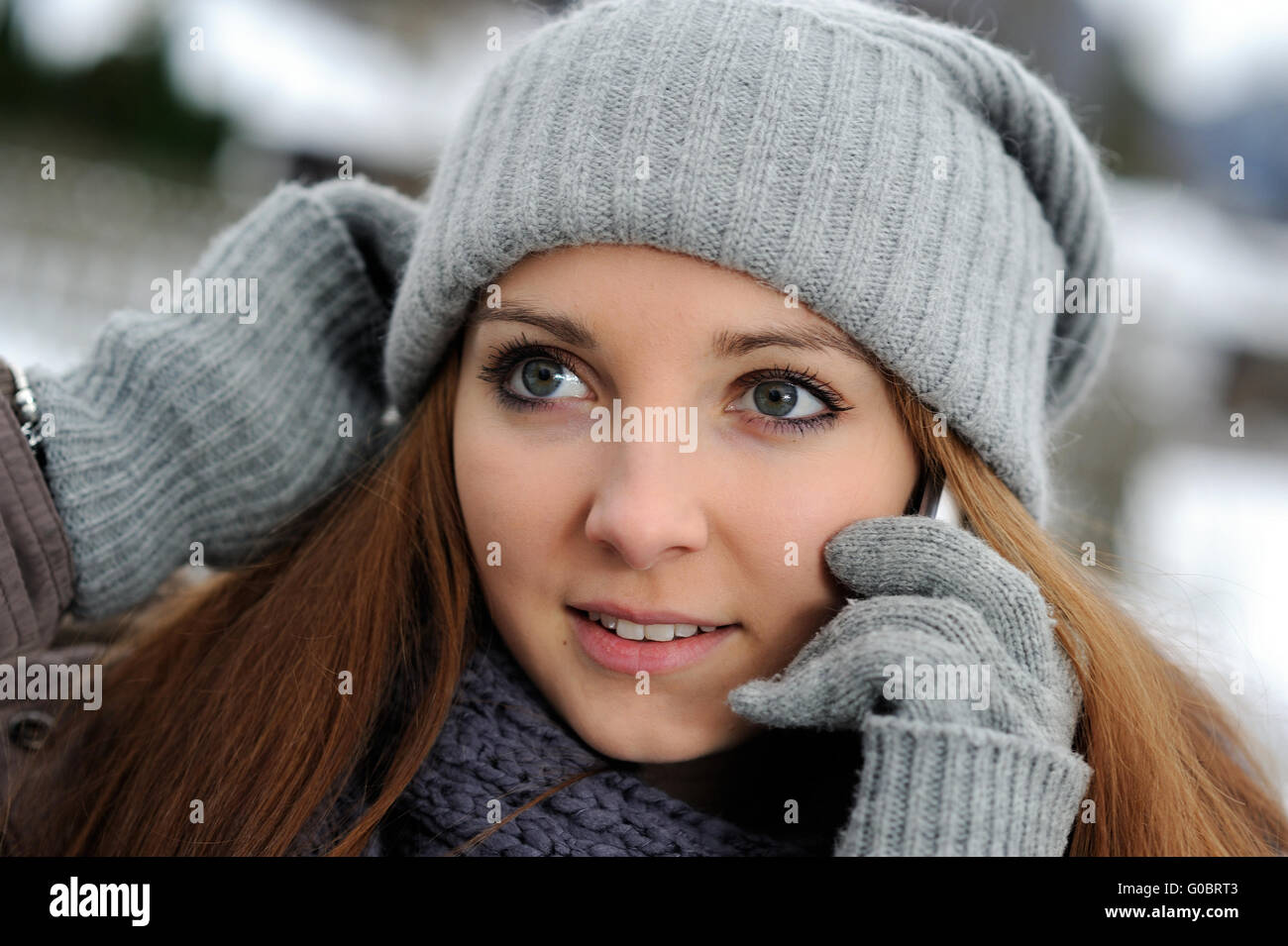 Jeune femme portant des vêtements d'hiver mobile avec Banque D'Images