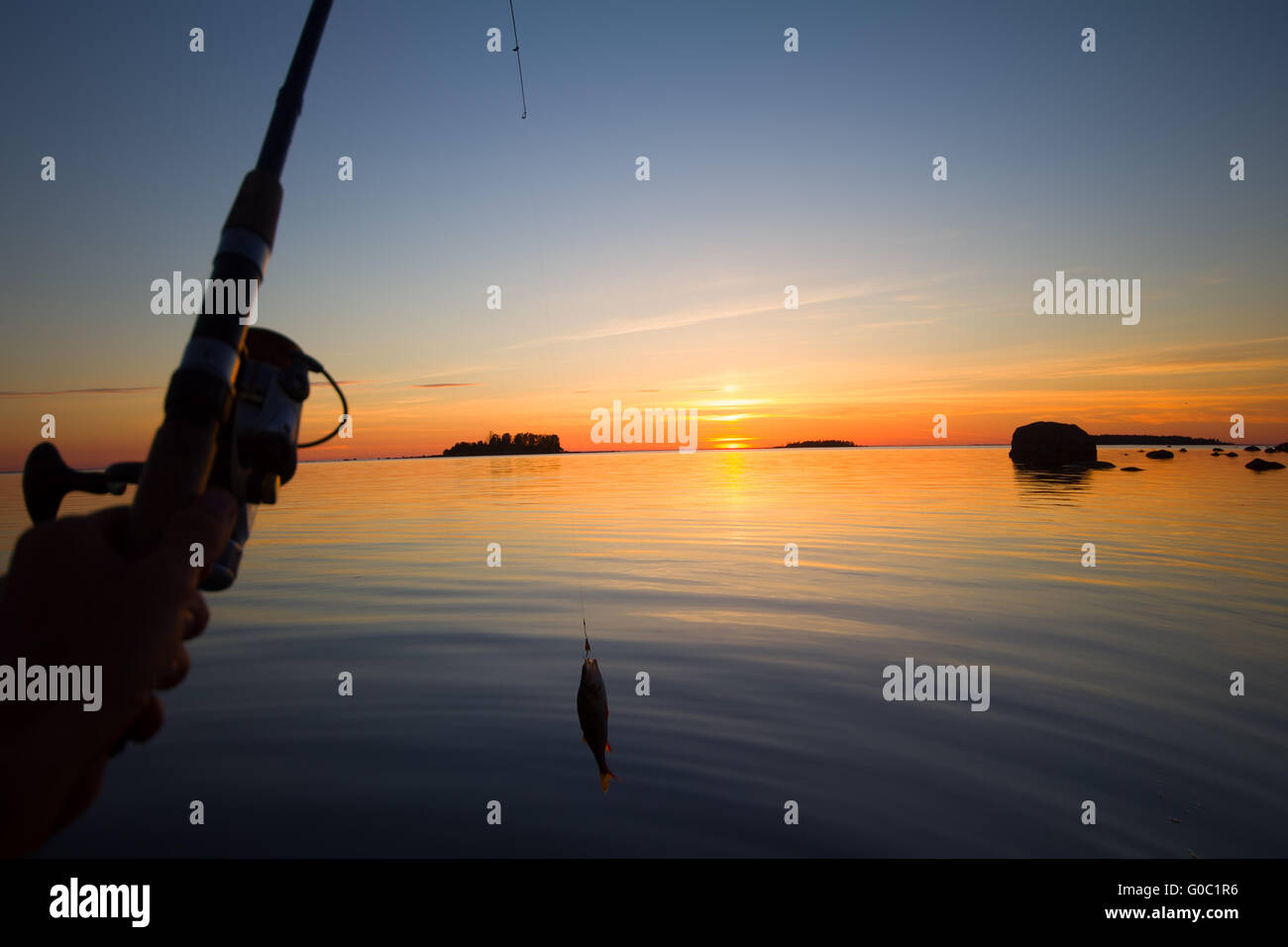 Rivière au coucher du soleil avec le bateau de pêche de la perche et d'une tige Banque D'Images