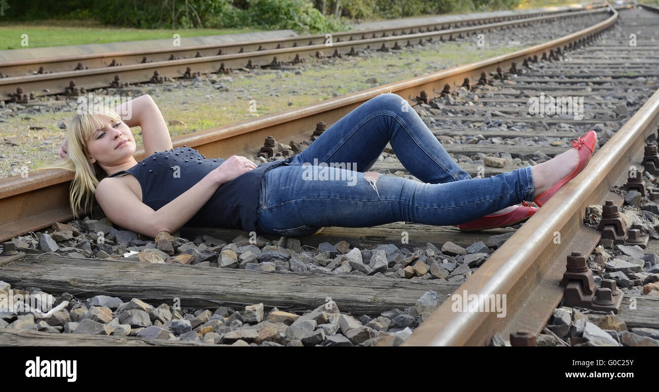 Femme couchée sur la voie ferroviaire Banque D'Images