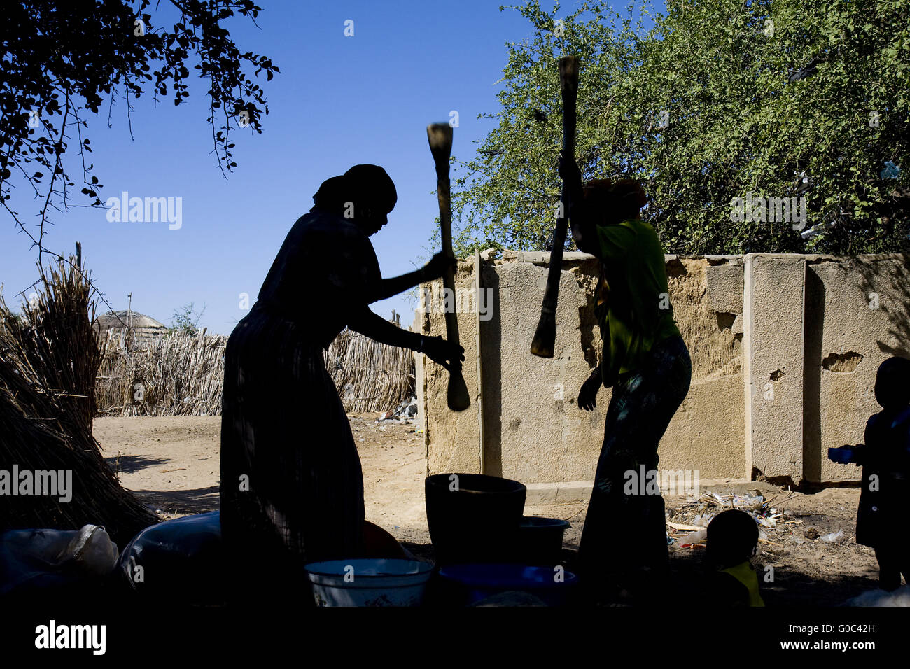 Femmes qui moudront millet dans des mortiers traditionnels. Ngalwa. Niger Banque D'Images