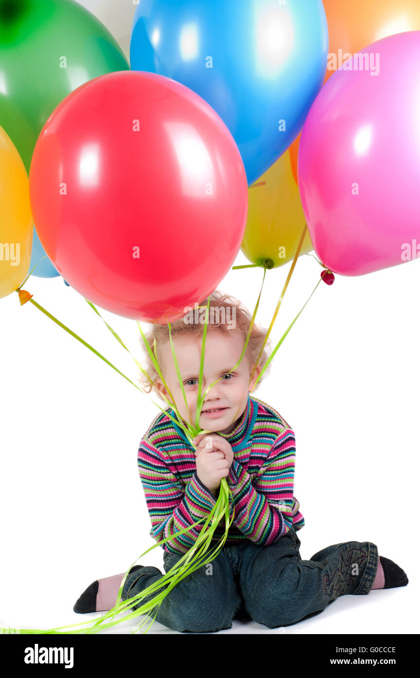 Petite fille aux ballons multicolores assis Banque D'Images