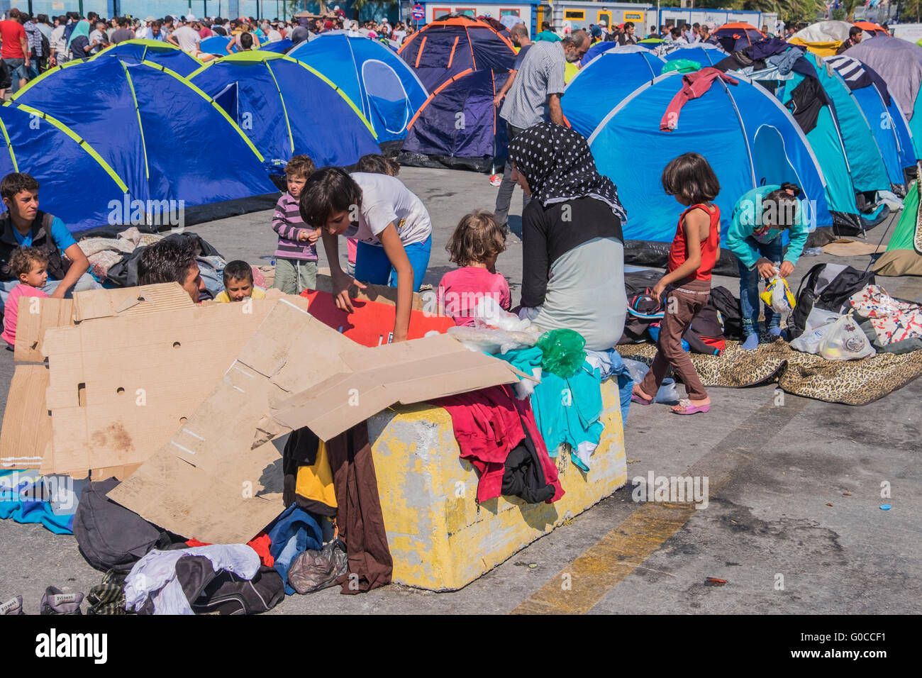 Les familles de réfugiés syriens préparer des éléments dans l'attente de traitement des demandes d'asile dans le port d'Mytillene, Grèce Banque D'Images