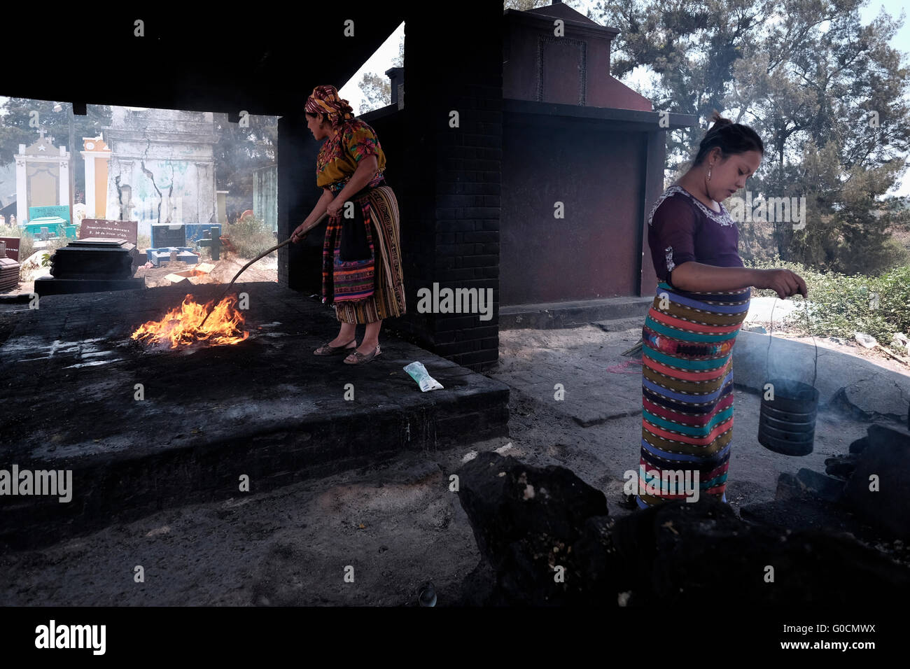 Femme locale effectuer une cérémonie maya K'iche encensoirs avec l'aide d'encens fumant au cimetière de Chichicastenango également connu sous le nom de Santo Tomás Chichicastenango une ville dans le département de Guatemala El Quiché, connu pour sa culture Maya Kiche traditionnels. Banque D'Images