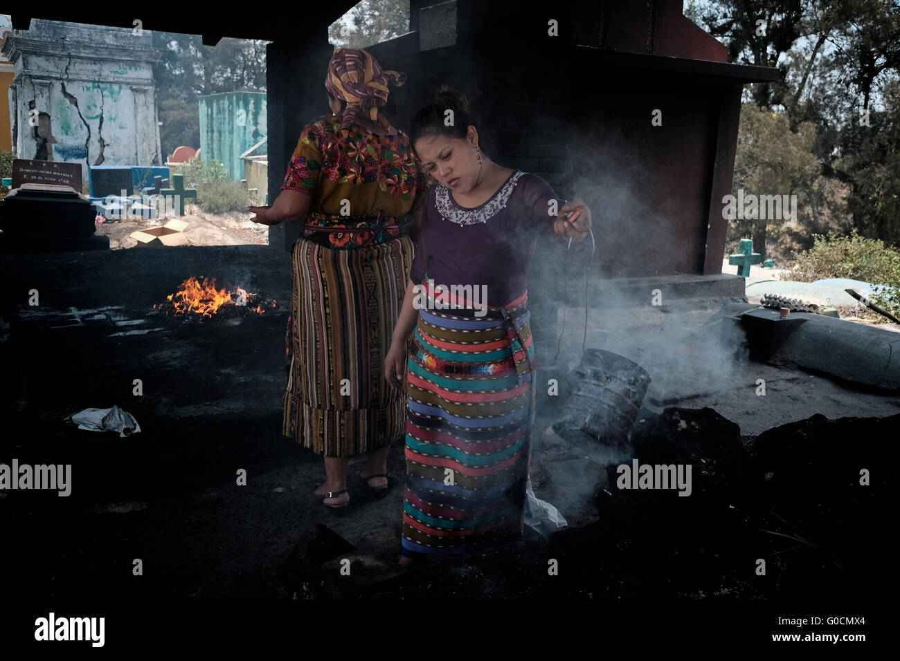 Femme locale effectuer une cérémonie maya K'iche encensoirs avec l'aide d'encens fumant au cimetière de Chichicastenango également connu sous le nom de Santo Tomás Chichicastenango une ville dans le département de Guatemala El Quiché, connu pour sa culture Maya Kiche traditionnels. Banque D'Images