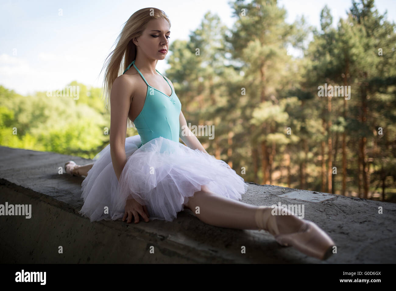 Ballerine gracieuse en tutu blanc assis sur les groupes Banque D'Images