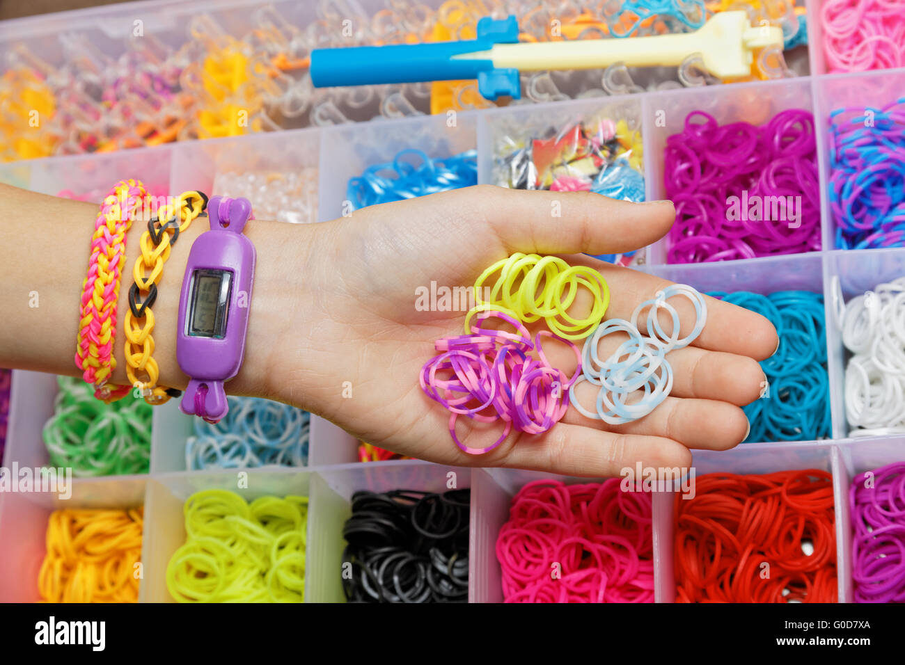 Une main avec un bracelet et un ensemble de bandes à tisser Banque D'Images