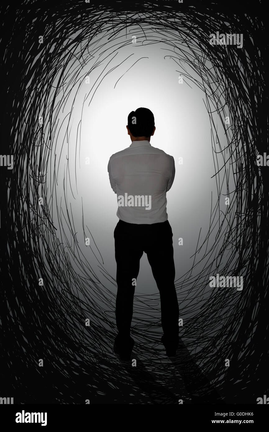 Image concept défi vue arrière d'un homme avec à la lumière vive à la fin du tunnel noir Banque D'Images