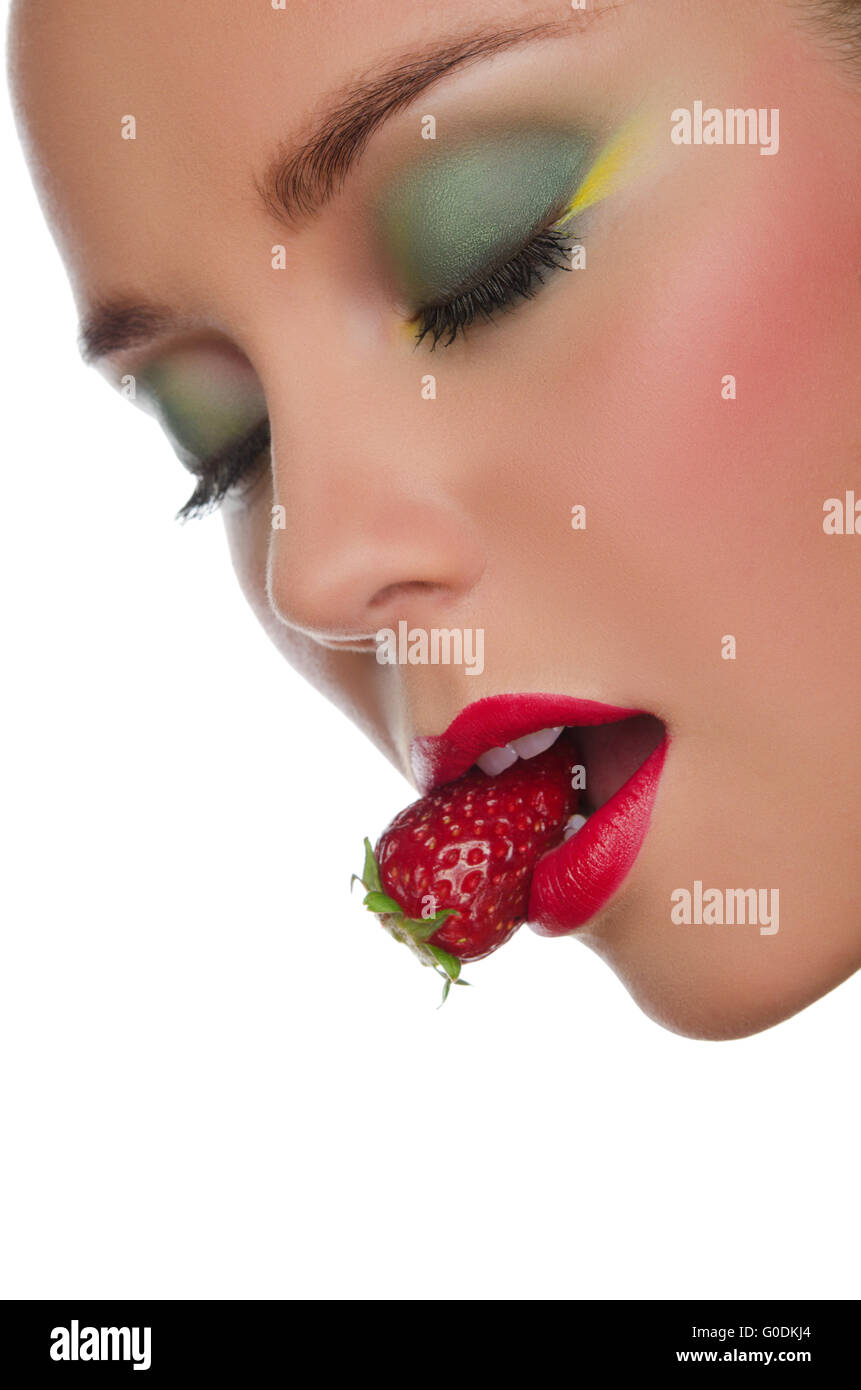 Visage de belle femme avec fraise dans la bouche Banque D'Images