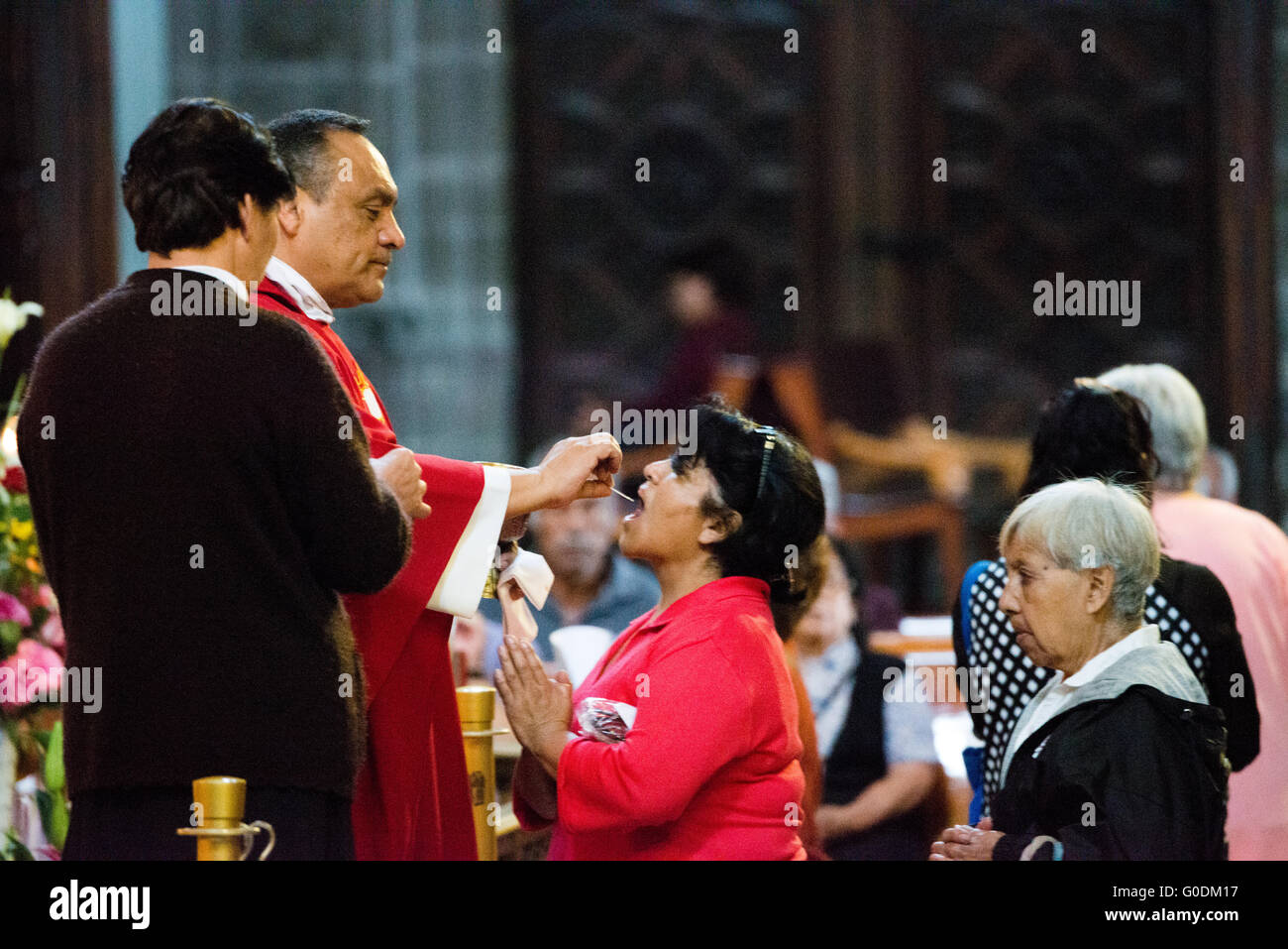 La VILLE DE MEXICO, MEXIQUE --une femme réception communion pendant la messe à l'autel du pardon dans le Metropolitcan cathédrale. Construite par étapes de 1573 à 1813, la cathédrale métropolitaine de Mexico est la plus grande cathédrale catholique romaine dans les Amériques. Il se trouve au cœur du quartier historique de la ville de Mexico le long d'un côté du Zocalo. Banque D'Images