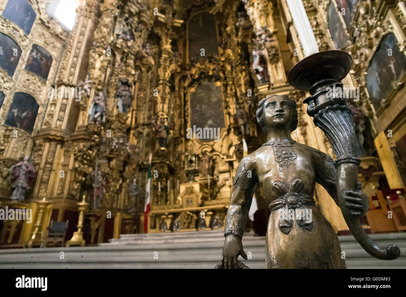 Cathédrale métropolitaine autel de los Reyes porte-bougie Mexico // MEXICO CITY, Mexique — un porte-bougie ornemental est placé au premier plan avec l'autel de los Reyes (autel des Rois) visible en arrière-plan dans la cathédrale métropolitaine de l'Assomption de la très Sainte Vierge Marie au ciel. Le retable baroque a été créé par Jerónimo de Balbás entre 1718 et 1737, introduisant la colonne estípite à l'architecture mexicaine et représentant l'un des plus beaux exemples de l'art churrigueresque dans les Amériques. Le retable de 25 mètres de haut (82 pieds) en compte douze Banque D'Images Cathédrale métropolitaine autel de los Reyes porte-bougie Mexico // MEXICO CITY, Mexique — un porte-bougie ornemental est placé au premier plan avec l'autel de los Reyes (autel des Rois) visible en arrière-plan dans la cathédrale métropolitaine de l'Assomption de la très Sainte Vierge Marie au ciel. Le retable baroque a été créé par Jerónimo de Balbás entre 1718 et 1737, introduisant la colonne estípite à l'architecture mexicaine et représentant l'un des plus beaux exemples de l'art churrigueresque dans les Amériques. Le retable de 25 mètres de haut (82 pieds) en compte douze Banque D'Images