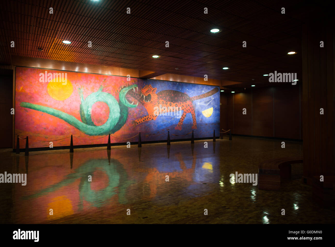 MEXICO, Mexique — la murale « Dualidad » de Rufino Tamayo domine le hall d'entrée du Musée national d'anthropologie. Créée en 1964, cette œuvre monumentale représente la lutte éternelle entre un jaguar et un serpent, représentant les dieux aztèques Tezcatlipoca et Quetzalcoatl. La murale illustre le concept aztèque fondamental de la dualité cosmique à travers des images symboliques et des couleurs vives. Banque D'Images