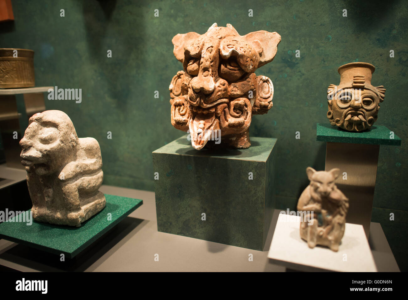 Figures de divinités en céramique mésoaméricaines Museo Nacional de Antropologia Mexico City | MEXICO CITY, Mexique — Un groupe de figurines en céramique précolombiennes occupe une vitrine du Museo Nacional de Antropología, dominé par une tête de divinité en terre cuite vive avec une bouche ouverte armée de crocs et des éléments de coiffe élaborés suggérant une divinité de la pluie ou du jaguar. À travers les cultures mésoaméricaines, les effigies en céramique creuses comme celles-ci servaient d'offrandes funéraires, de récipients rituels et de brûle-parfums — et leur variété stylistique est l'un des principaux outils utilisés par les archéologues pour retracer les réseaux commerciaux et les contacts culturels entre di Banque D'Images